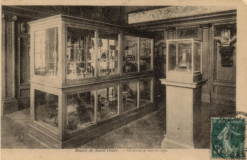 On voit ici les vitrines ou sont exposés des objets d'orfévrerie du moyen âge. Sur la droite on peut voir dans la petite vitrine le pied de croix champlevé et émaillée, d'une valeur inestimable, datant du XII siècle et provenant de l'église de l'abbaye Saint Bertin.